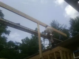 Carpenter setting a ridge beam over a new addition frame — Ice Dam Removal by Roofing Brothers in Hensley