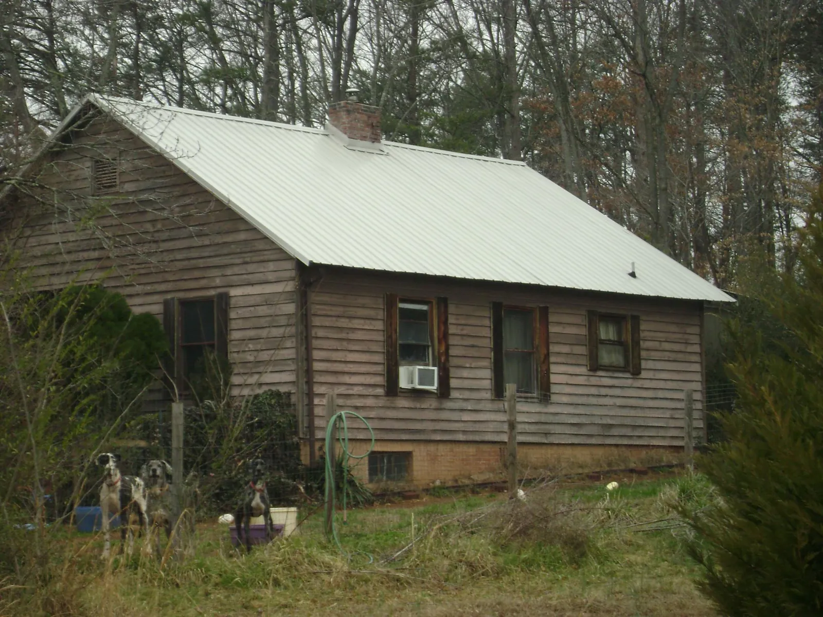 White metal roof on an old wood sided farmhouse, from a Metal Roof Installation job in Hensley